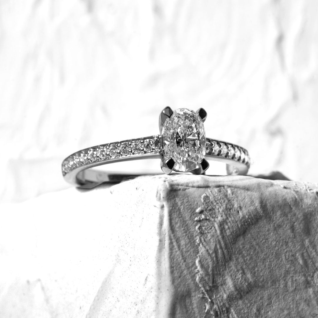 Anillo cintillo diamante oval acompañado